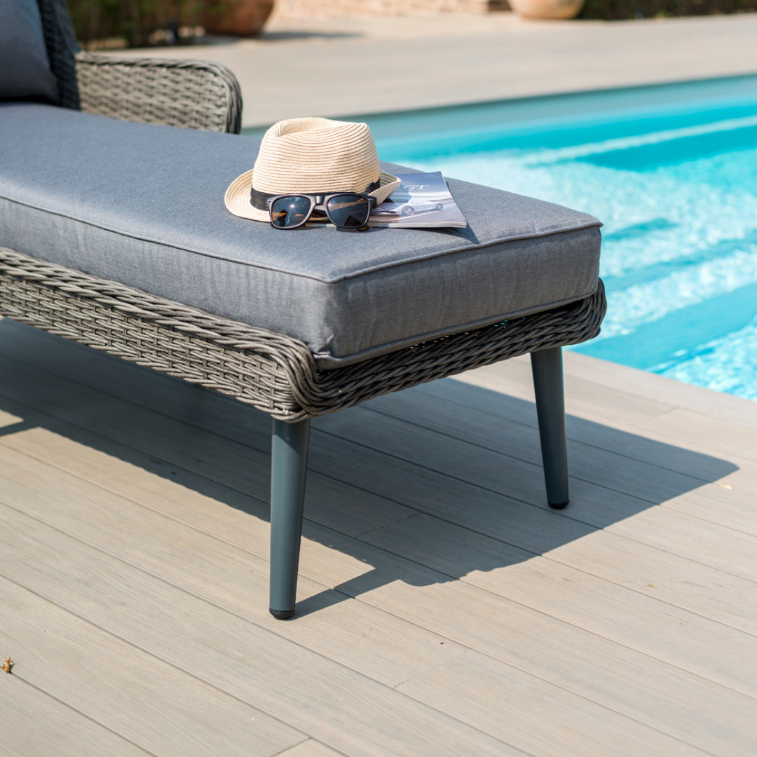 Select Composite Decking with lounger beside an outdoor pool with straw hat and sunglasses on top.