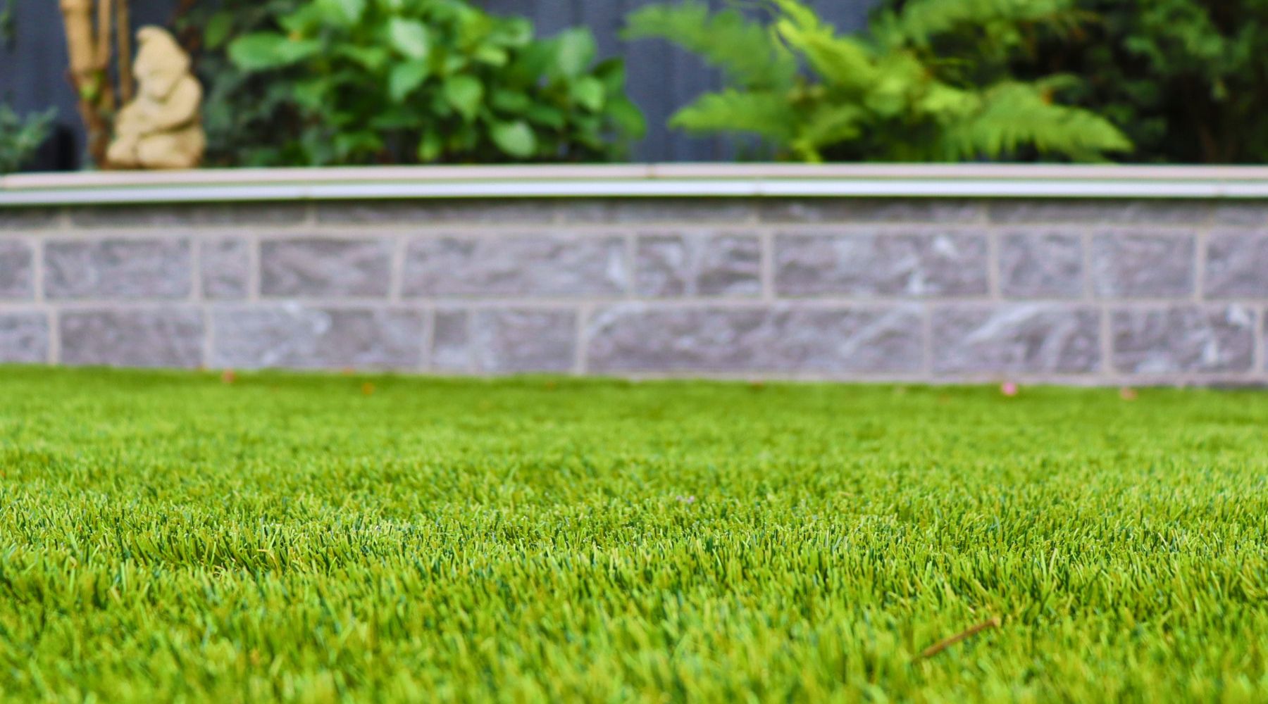 Select Living Group Artificial Grass with small garden wall in the background.