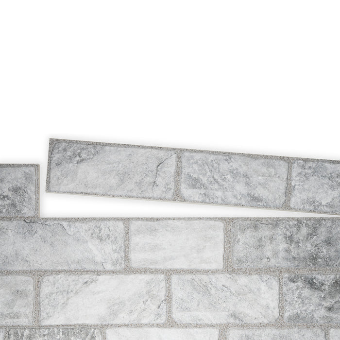 An example of a section of Cavo Porcelain Cladding. The colour is a darkish grey with a marbled effect.  One line of the tiles is separate from the main panel to show how they fit together.