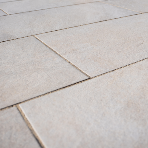 Close-up of Cristallo Beige Porcelain Paving from Select Living Group with visible grout lines on a floor.