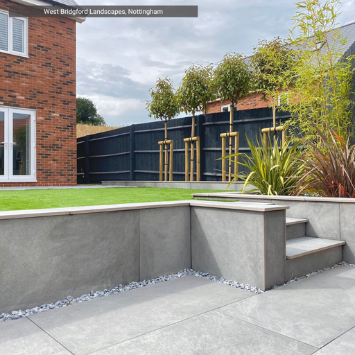 Modern garden with Paradiso Light Grey Porcelain Paving from Select Living Group., steps, and plants.