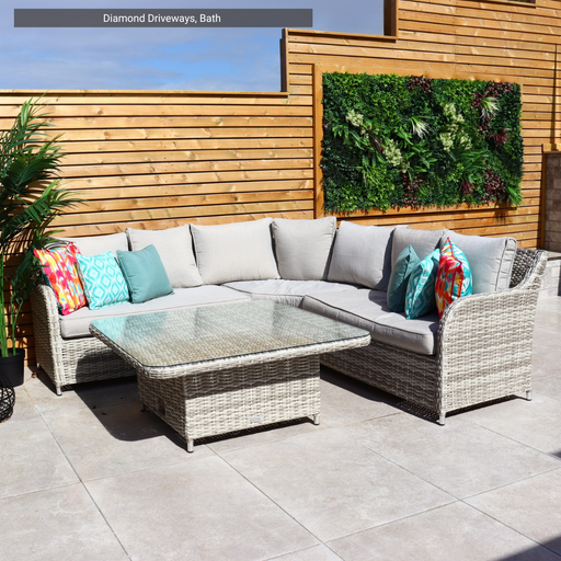 Outdoor patio set with a sectional sofa and coffee table on Solaro Light Grey Porcelain Paving from Select Living Group.