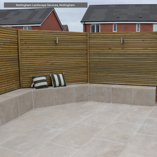 Outdoor seating area with a wooden bench and cushions, featuring Solaro Taupe Porcelain Paving from Select Living Group.