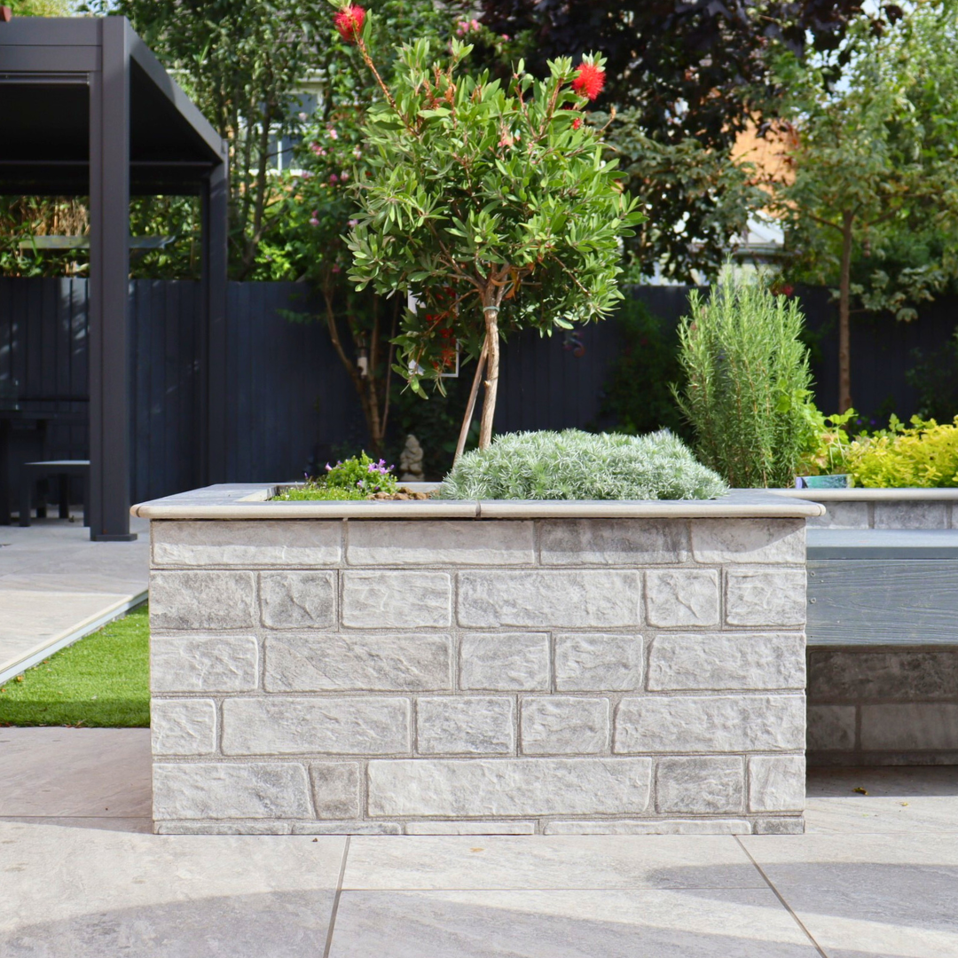 Small garden tree in a square garden wall on top of Select Living Group Porcelain Paving.