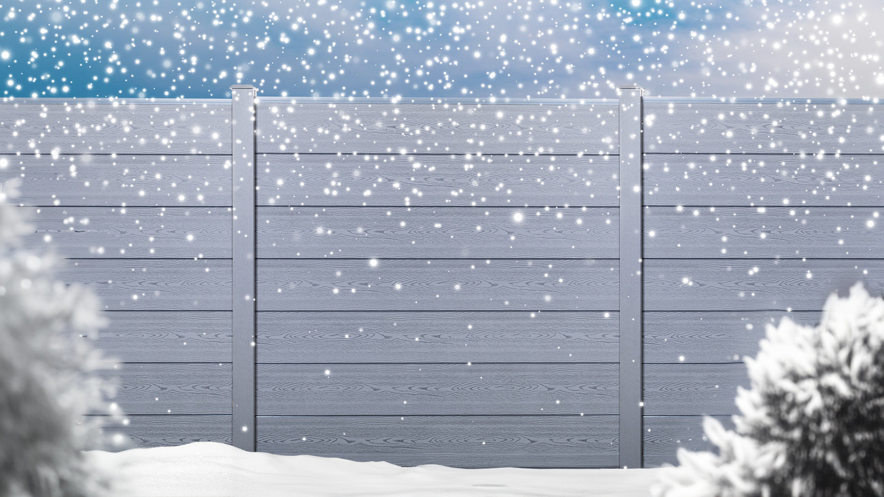 Select composite fencing in a garden during winter whilst it snows