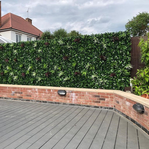 Backyard with artificial green wall, deck, and house in the background