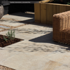 Paved patio area using Sena Porcelain Paving from Select Living Group with a wicker chair and plants.