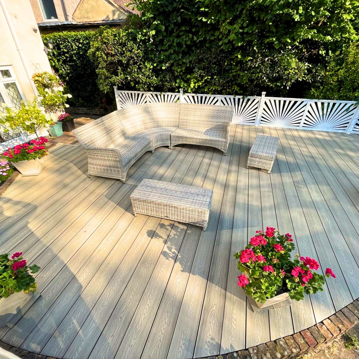 outdoor composite decking with wicker furniture and potted plants. 